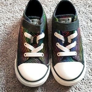 Converse black sneakers with rainbow stripes.